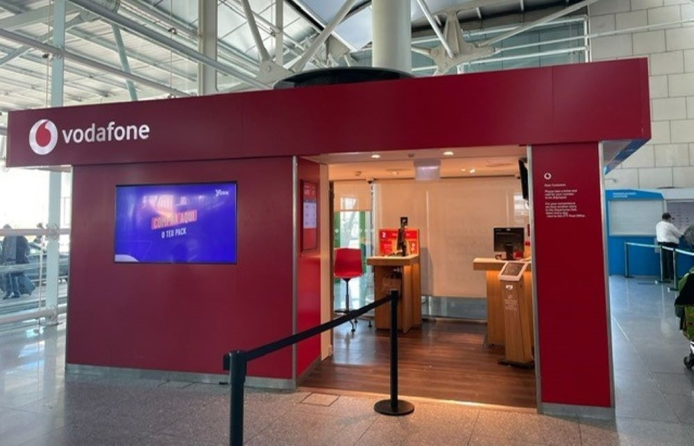 Vodafone has a store located next to luggage belt 9 that is open from 7AM to 10PM